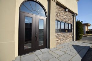 Summer exterior restoration work on a commercial building under clear weather conditions