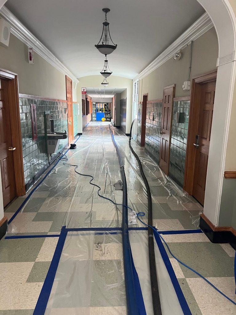 ater extraction in a school hallway after flooding to prevent structural damage and mold growth