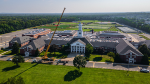 Wide view of RENU crew installing a new HVAC system on a school rooftop