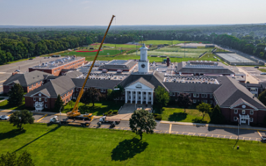 Wide view of RENU crew installing a new HVAC system on a school rooftop